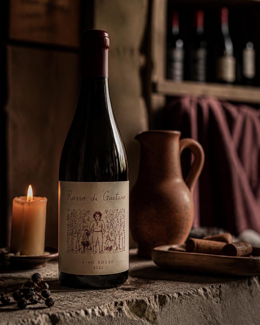 Garrafa de vinho natural em ambiente de adega, com vela acesa ao lado